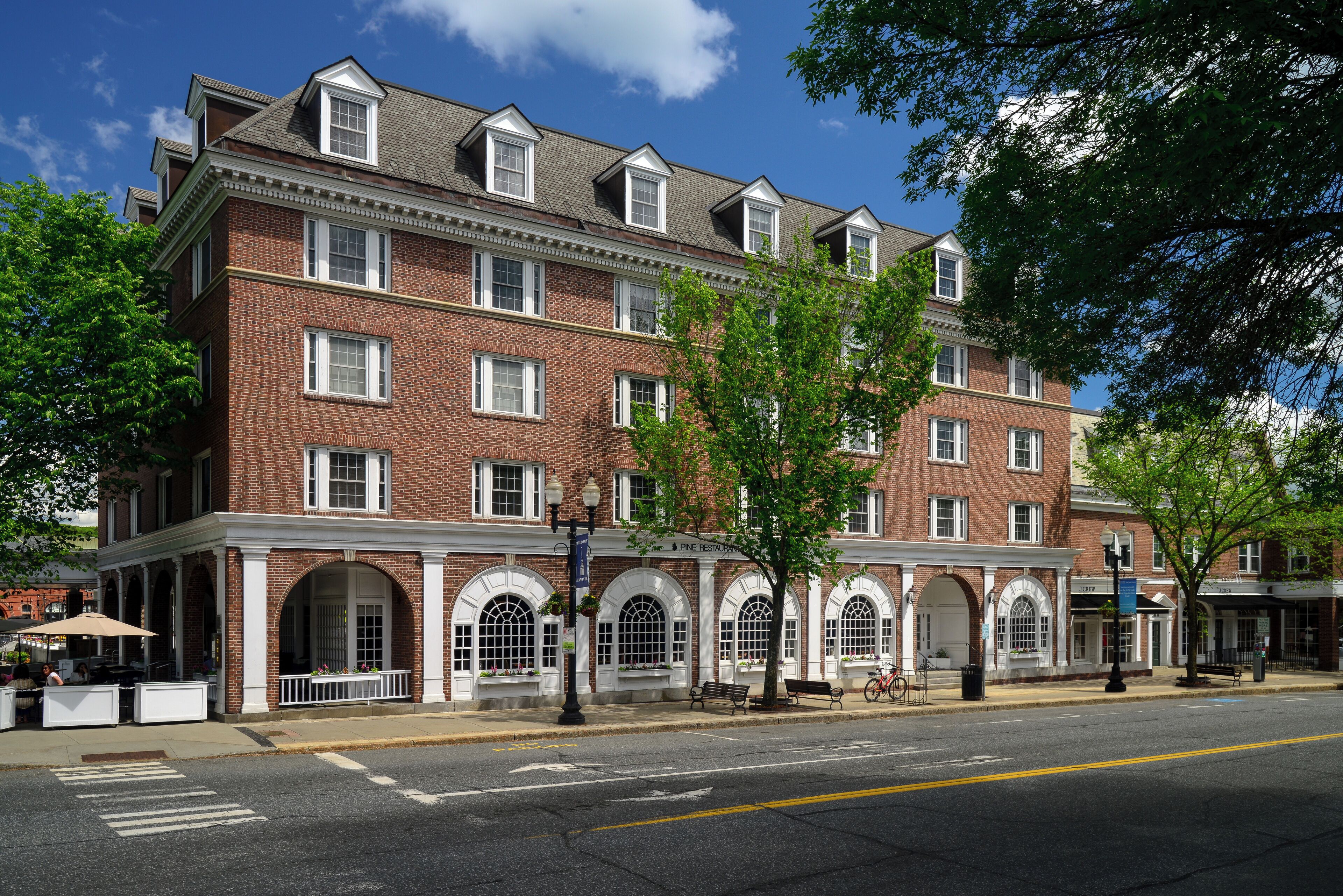 A multi-story brick building with arched windows and a flat roof.