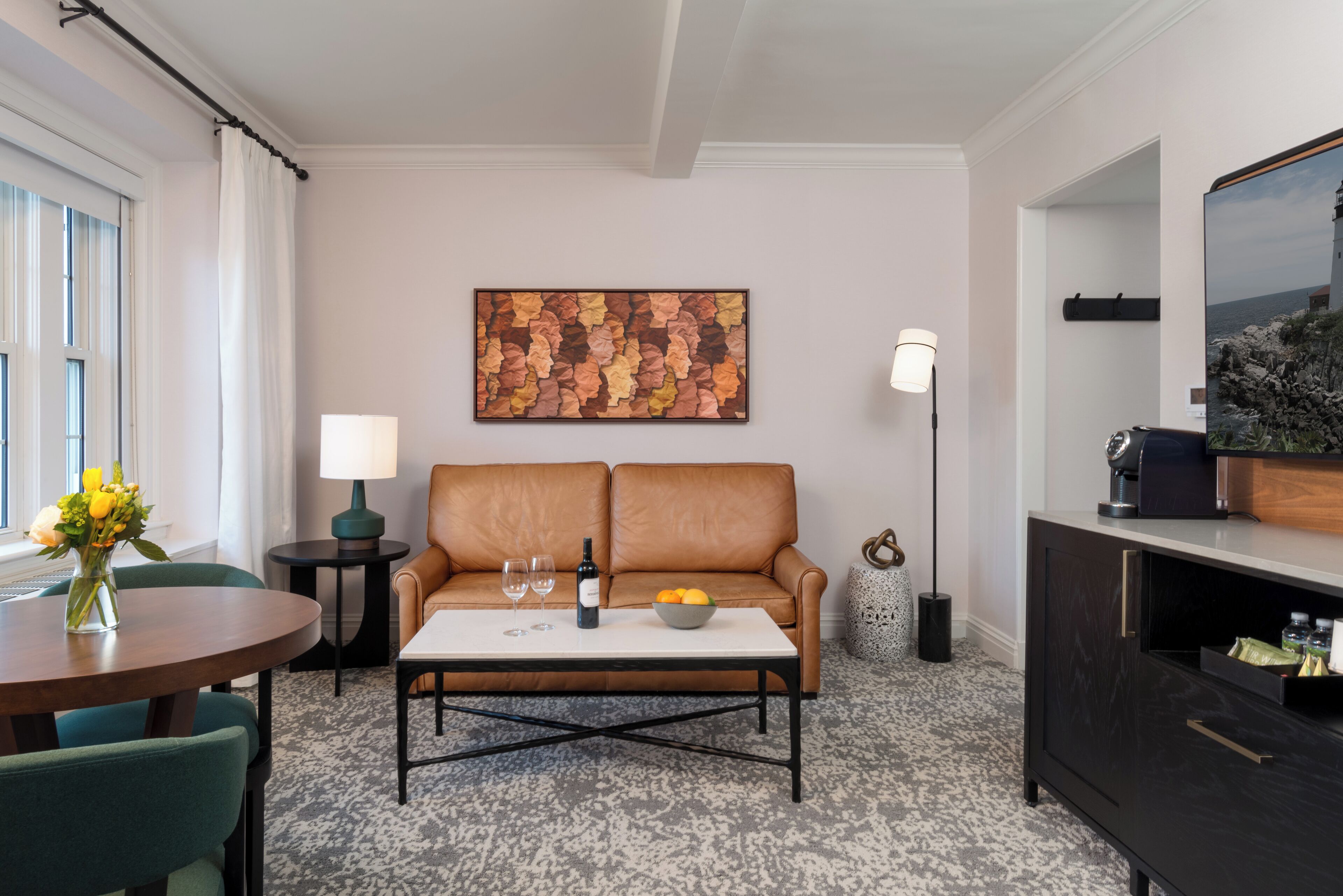 Ein modernes Wohnzimmer mit einer Couch, einem Couchtisch und einem Bild an der Wand.