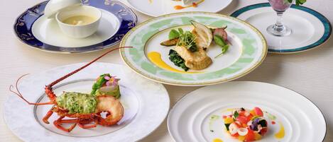 A variety of dishes on plates, including seafood and salads.