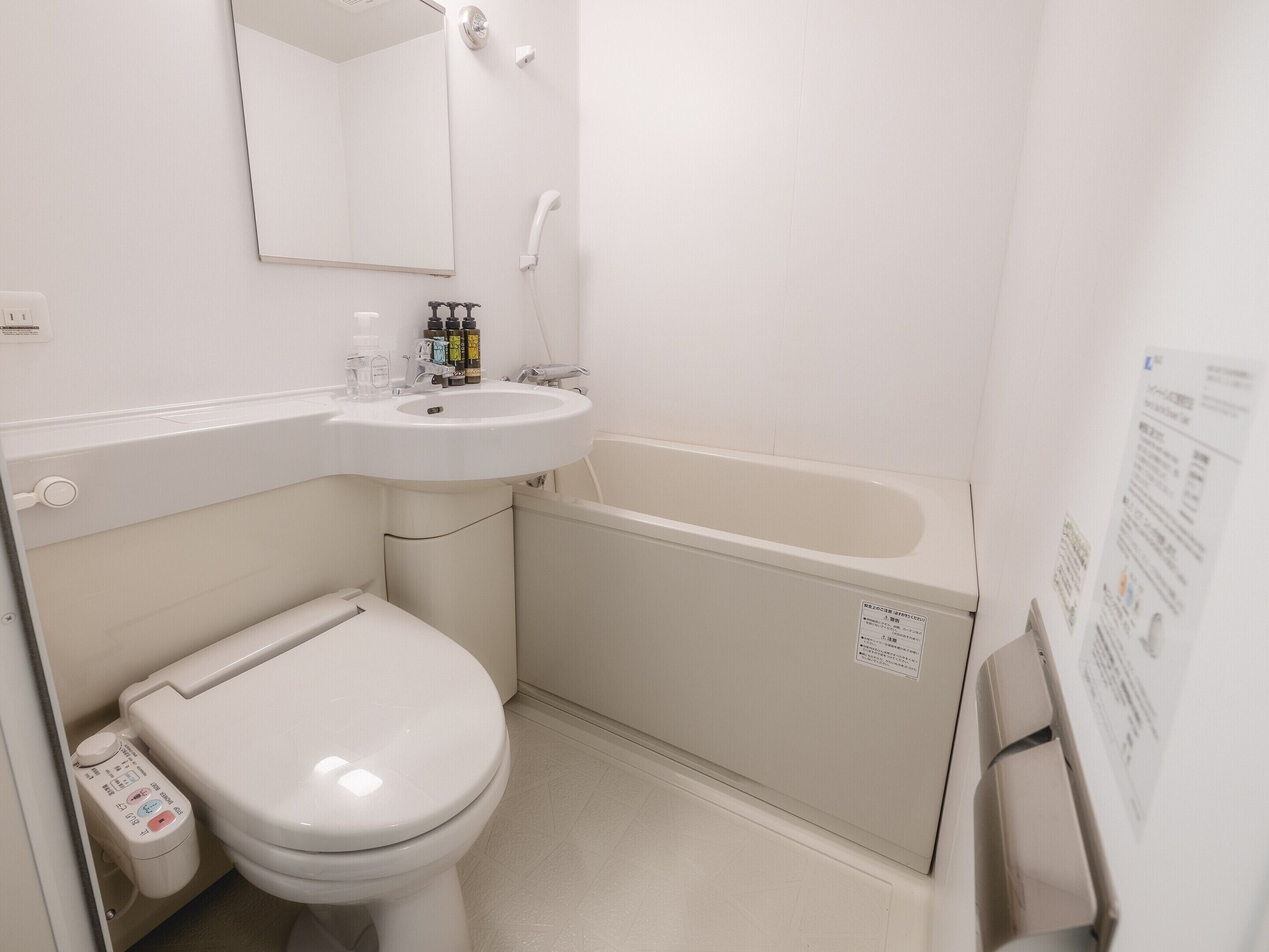 A small, white bathroom with a toilet, sink, and bathtub.