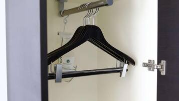 Una habitación con un perchero, una puerta con pomo plateado y un interruptor de luz a la vista.