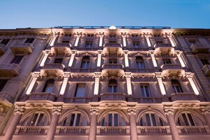 A multi-story building with classical architecture, featuring ornate balconies and large windows.