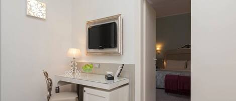 A small, private room with a desk, chair, and a television mounted on the wall.