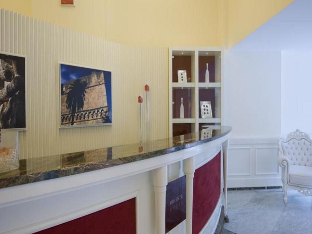 A reception area with a marble counter, a framed picture, and a white chair.