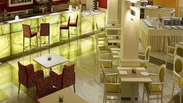 A hotel lobby with a bar area, seating arrangements, and a reception desk.