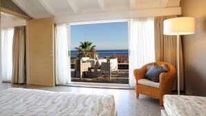 A hotel room with a balcony, a bed, a chair, and a lamp. - Residence Oliveto (Ceriale)