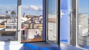 A room with a large window offering a view of a cityscape. - La Estrella de Tarifa (Tarifa)