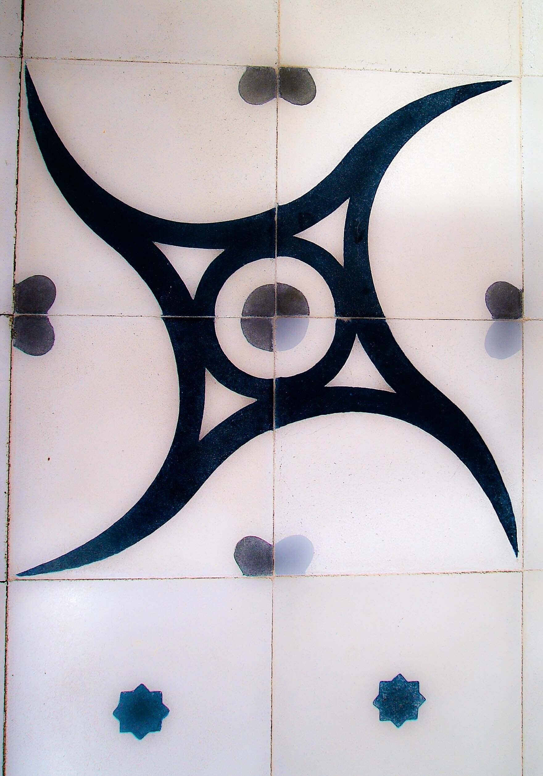 Pared de azulejos con un diseño geométrico que presenta un círculo central y cuatro círculos más pequeños.
