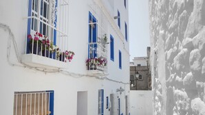 A narrow street with white buildings, blue window frames, and a cobblestone path. - La Estrella de Tarifa (Tarifa)