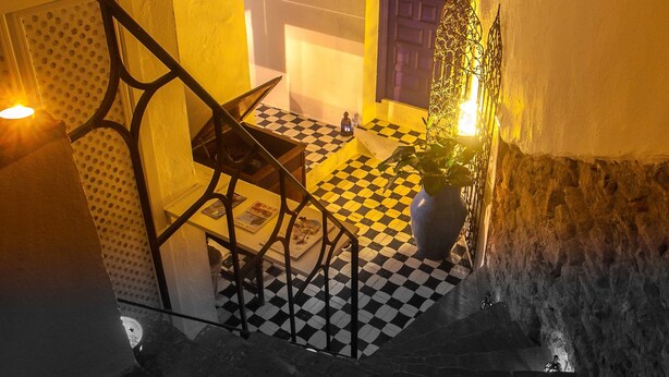 A staircase with checkered flooring, a hanging light fixture, and a potted plant. - La Estrella de Tarifa (Tarifa)