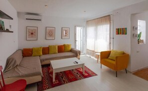 A modern living room with a sofa, armchair, coffee table, and a red patterned rug. - La Estrella de Tarifa (Tarifa)