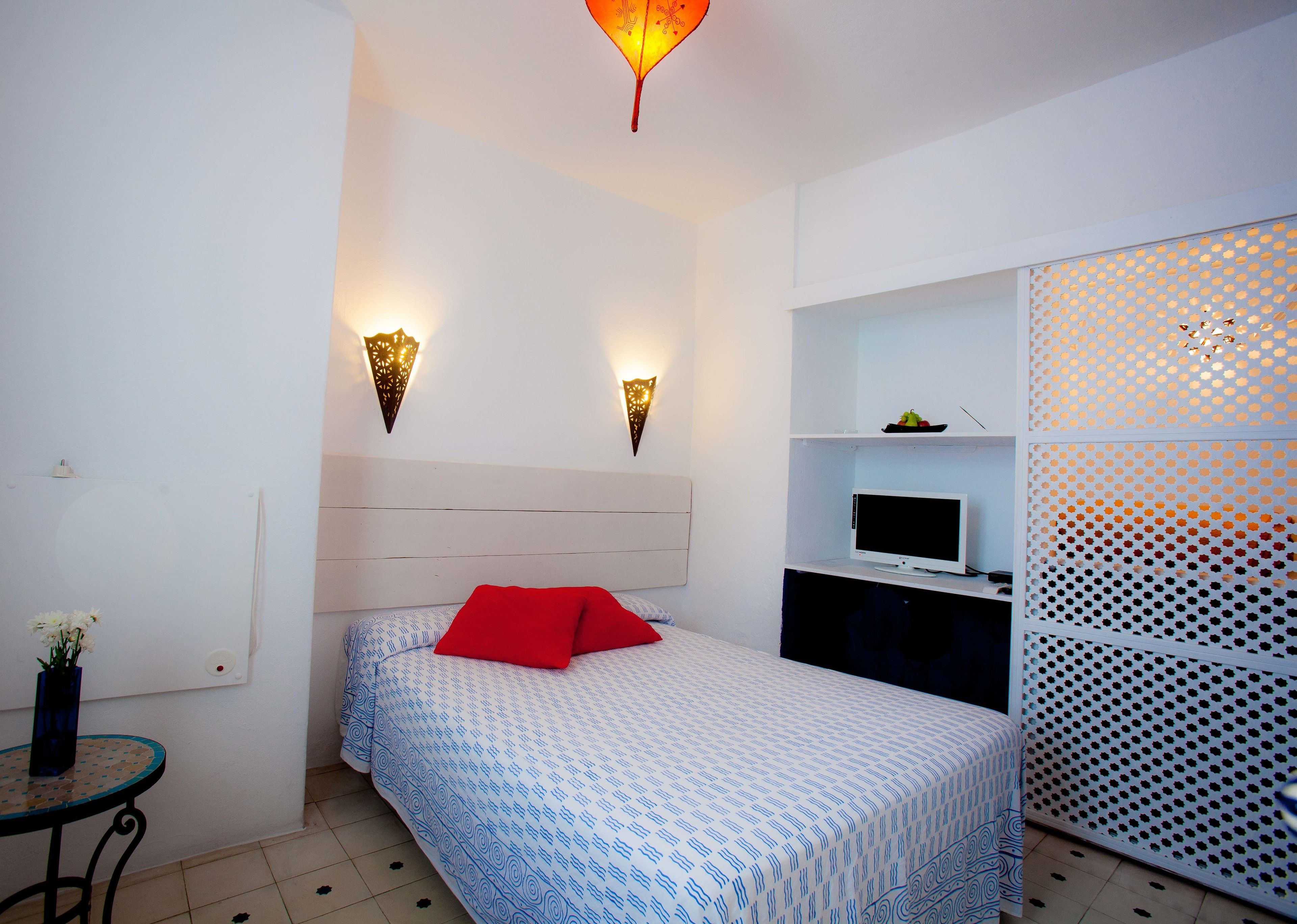 A bedroom with a bed, a TV, and a decorative wall panel.