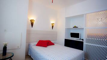 A bedroom with a bed, a TV, and a decorative wall panel.