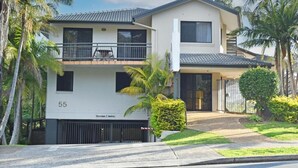 Un edificio residencial de dos pisos con balcón, garaje y señal de altura máxima.