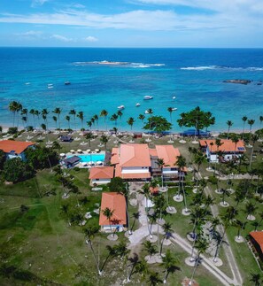 En la playa, arena blanca, sillas reclinables de playa, sombrillas