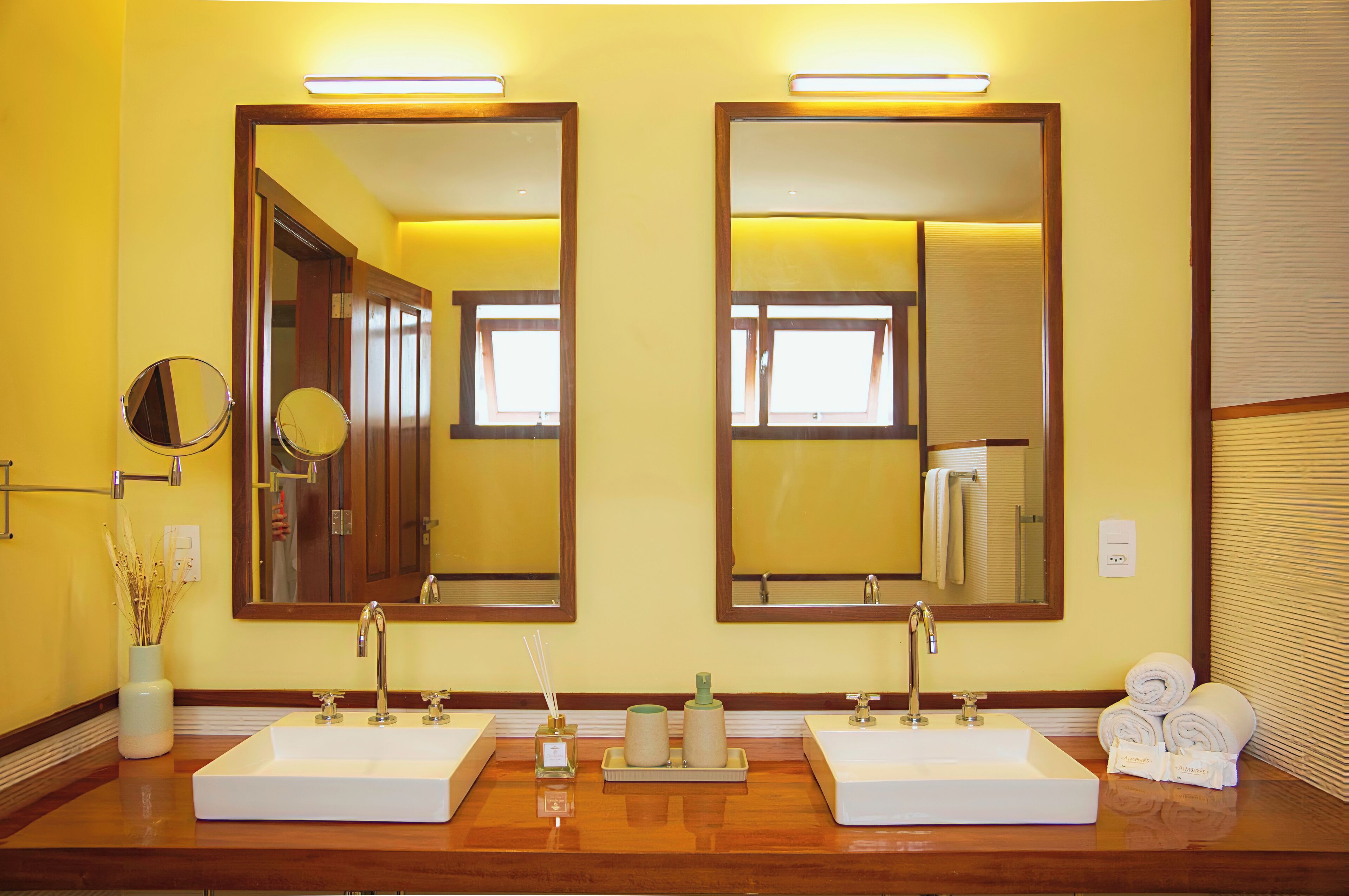 A bathroom with two sinks, large mirrors, and a wooden vanity.
