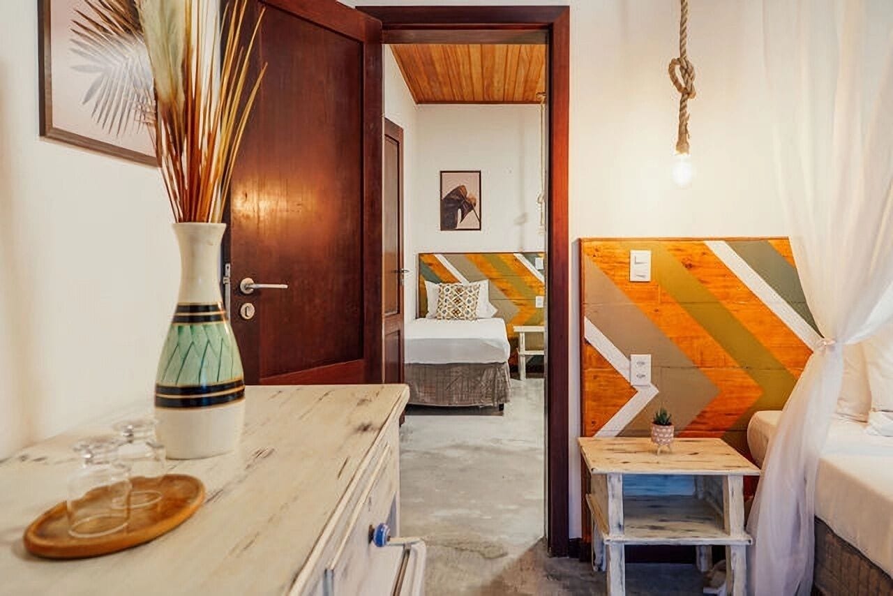 Habitación de hotel con cama, mesita de noche y un panel decorativo en la pared.