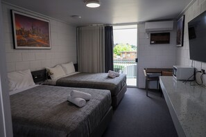 A hotel room with two beds, a desk, a television, and a cityscape painting. - Bendigo Motor Inn (Kangaroo Flat)