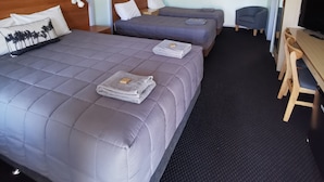 A hotel room with two beds, a desk, a chair, and a television. - Bellview Motel (Narrabri)