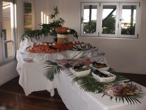 Une table de buffet garnie de divers plats et agrémentée d’un centre de table décoratif.