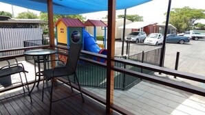 A covered outdoor area with a playground, including a slide and play structures, and a seating area with tables and chairs. - Blackwater Hotel Motel (Blackwater)