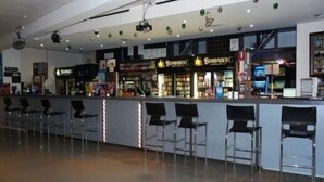 A bar area with a counter and bar stools, a ceiling with recessed lighting, and a visible sign for 'BUNDABERG'. - Blackwater Hotel Motel (Blackwater)