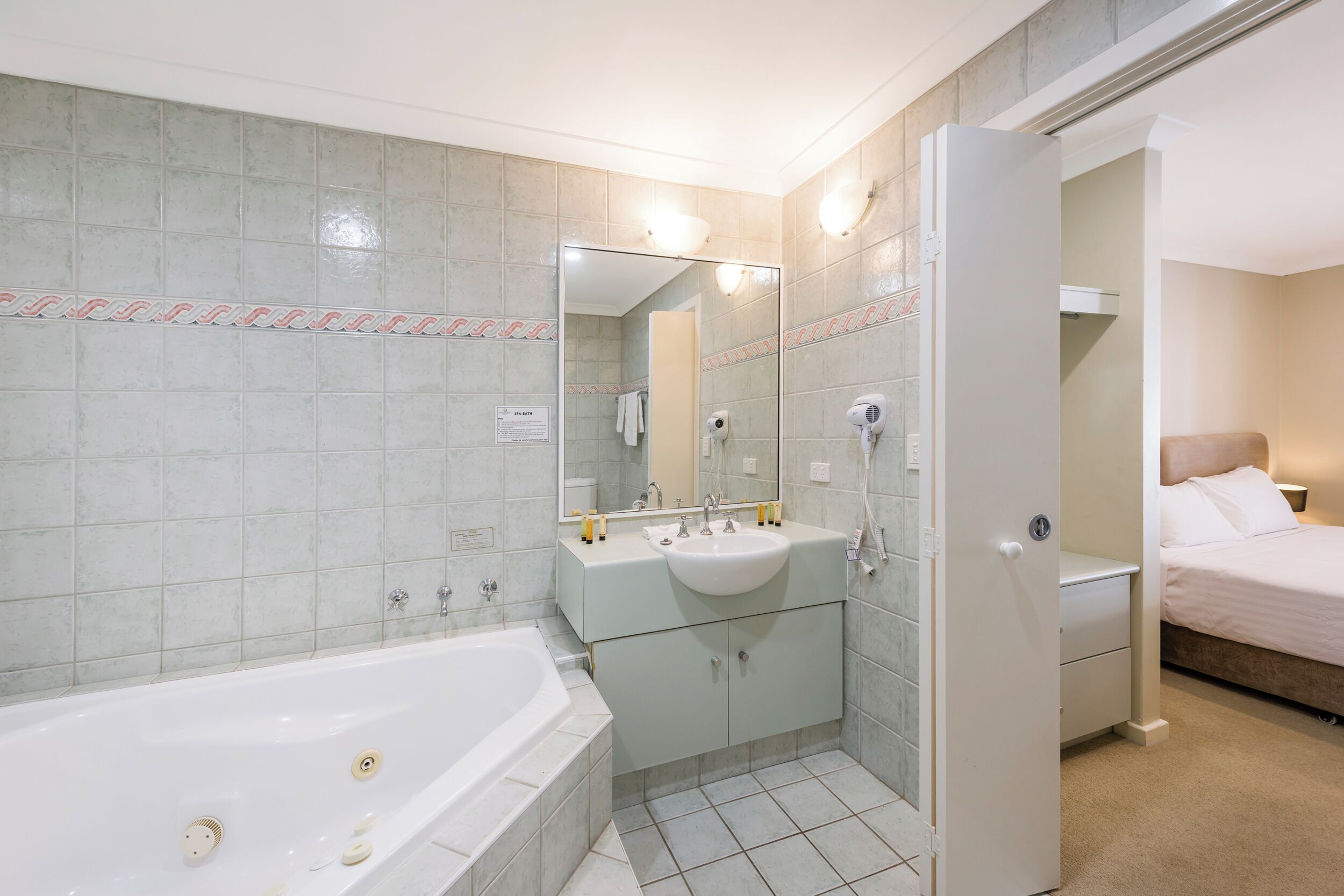 Un baño moderno con bañera, lavabo y espejo.
