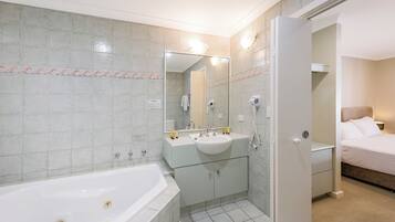 Un baño moderno con bañera, lavabo y espejo.