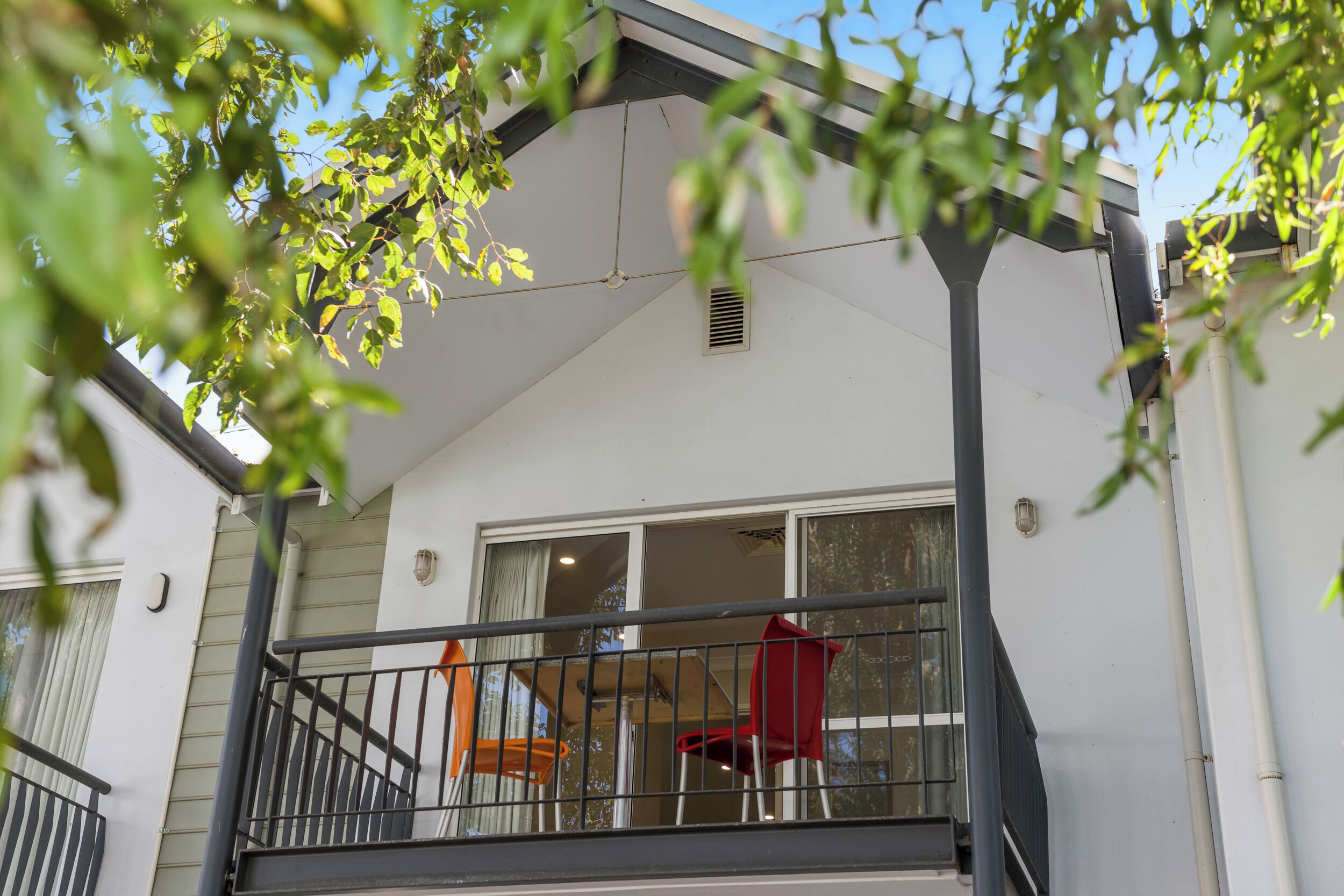 A balcony with a railing, a window, and a door.