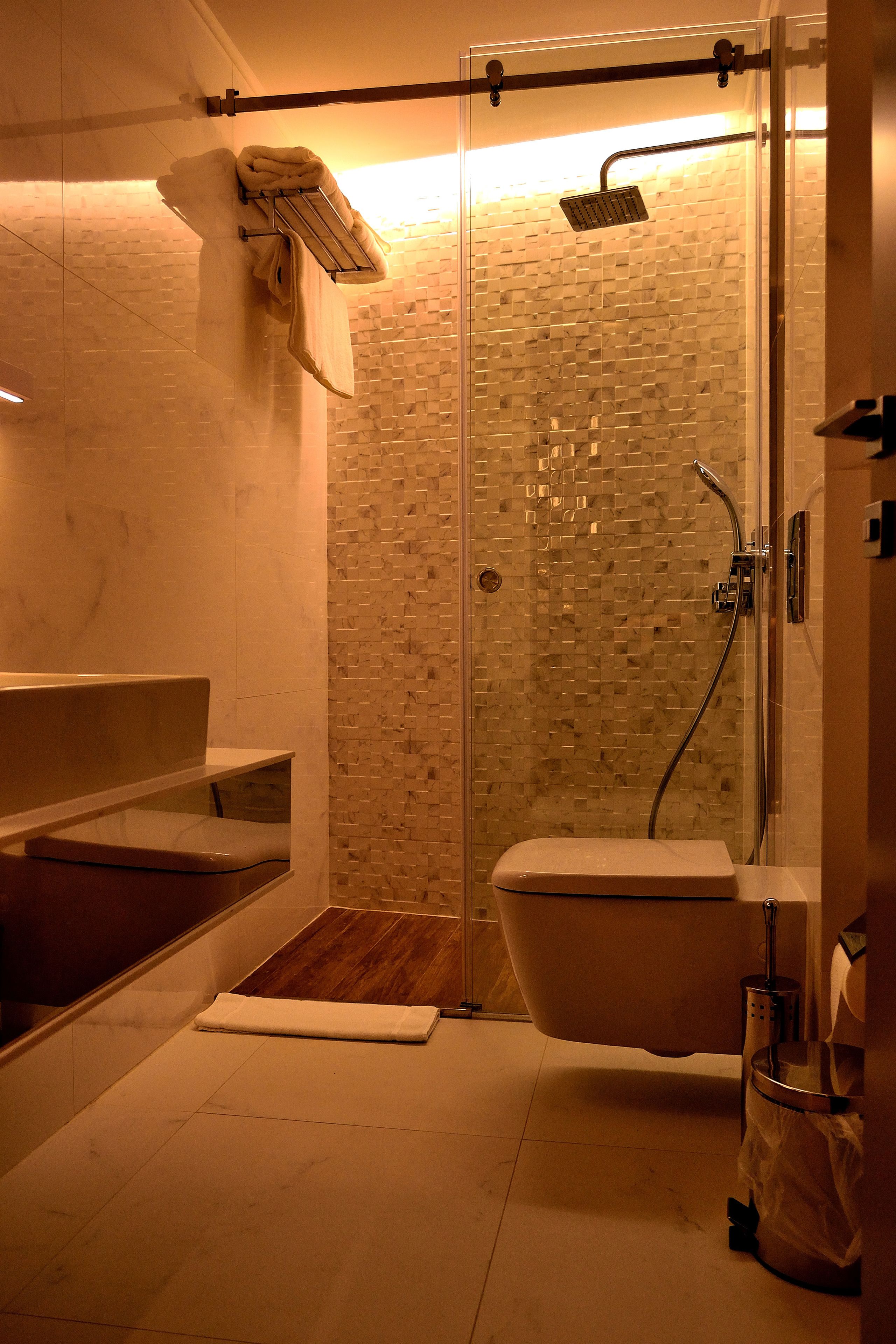 junior suite (single use) | bathroom | deep-soaking bathtub, rainfall showerhead, designer toiletries