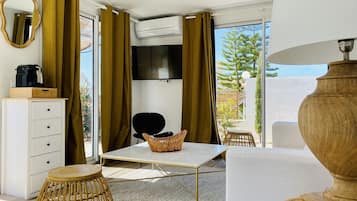 Suite Deluxe, 1 habitación | Área de sala de estar | Televisión de pantalla plana de 36 pulgadas con canales digitales