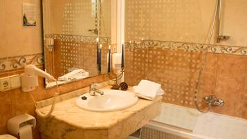 Un baño con lavamanos, espejo, inodoro y ducha.