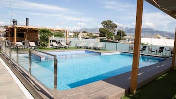 Una piscina al aire libre, tumbonas