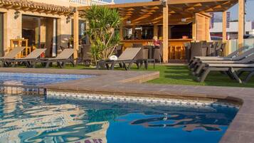 Una piscina al aire libre, tumbonas