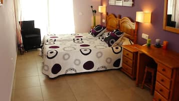 A bedroom with a bed, a desk, and a chair.