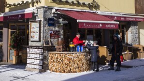 A small outdoor café with a stone counter and a red awning. - Hotel Touring Livigno (Livigno)