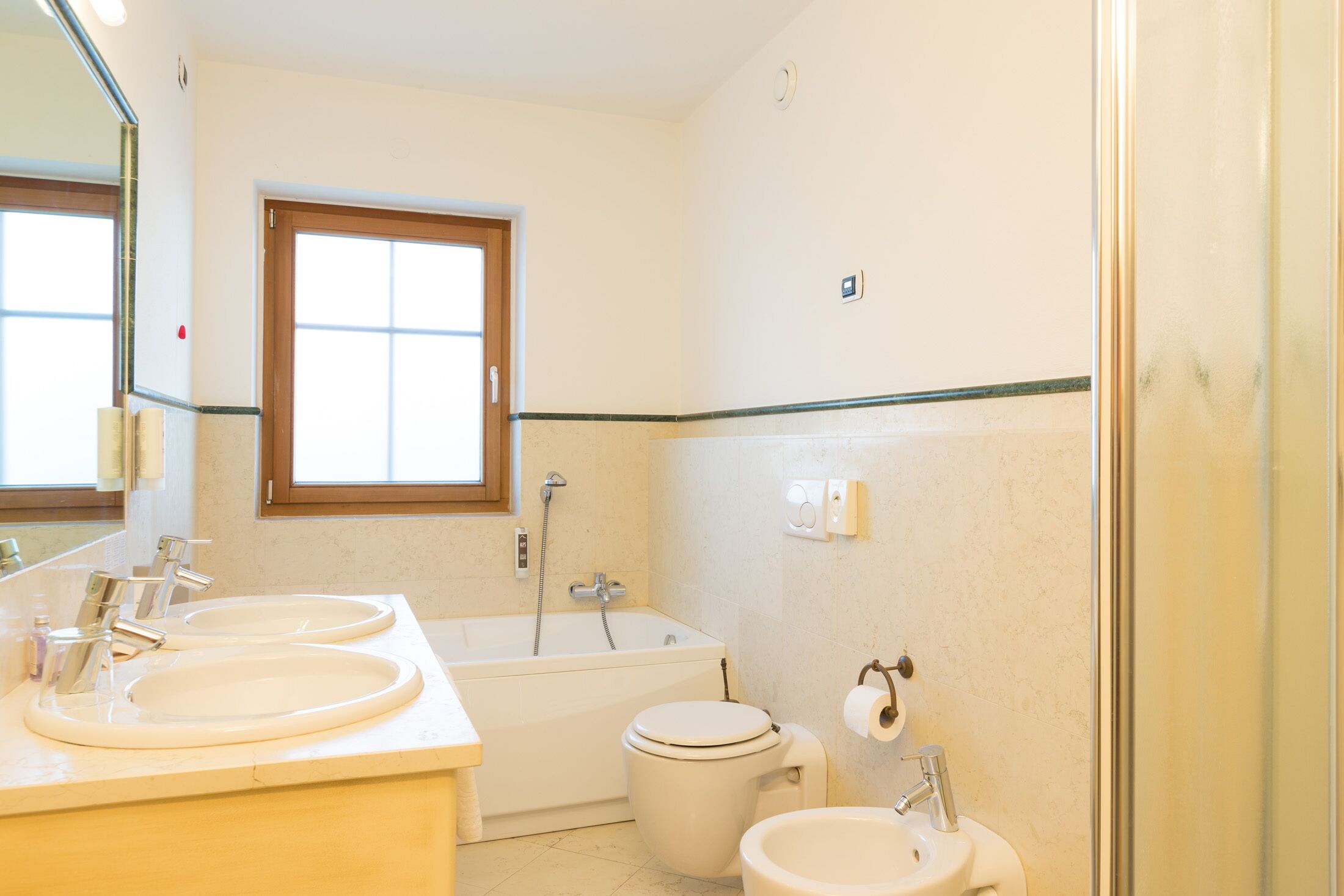 Une salle de bain avec deux lavabos, une baignoire et des toilettes.