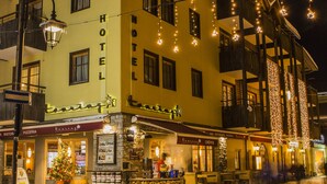A hotel with a yellow facade, multiple windows, and a balcony. - Hotel Touring Livigno (Livigno)