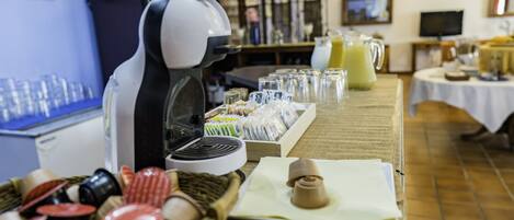 A buffet setup with a coffee machine, various food items, and a beverage dispenser.