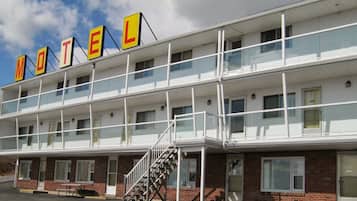 A motel with a two-story structure, multiple windows, and a prominent 'MOTEL' sign.