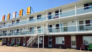 A motel with a two-story structure, a visible staircase, and a row of rooms with windows. - Hillside Motel (Saint John)