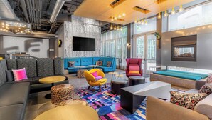 A modern lounge area with a blue sofa, yellow armchair, and various seating options.