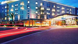 A modern hotel with a large entrance, multiple floors, and a well-lit facade.
