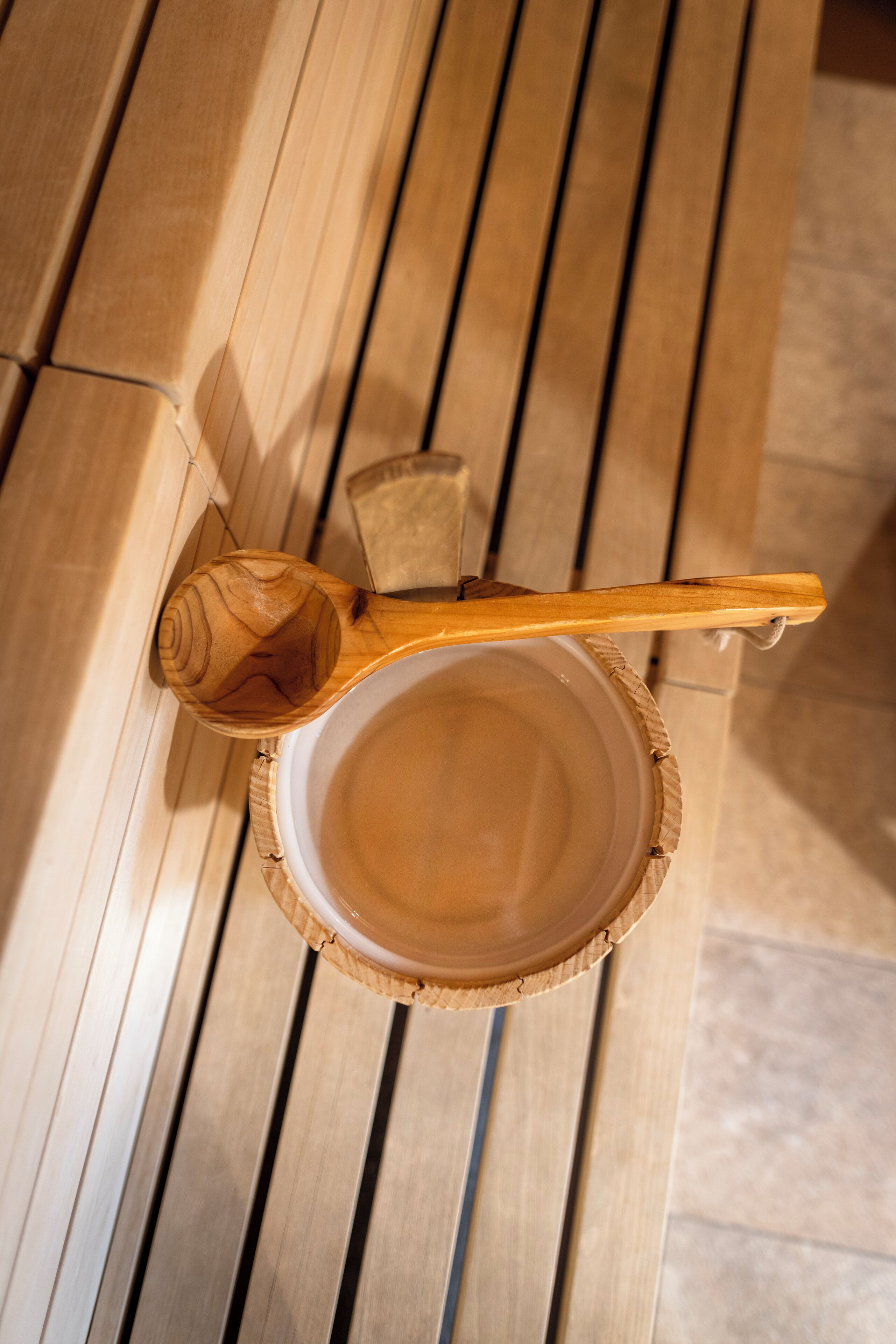 A wooden spoon resting on a ceramic bowl.