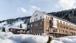 Un hôtel à étages, doté de grandes fenêtres et d’un toit plat.