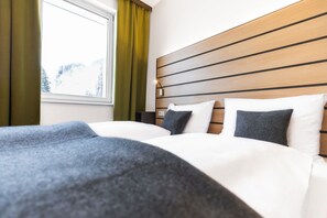 Ropa de cama hipoalergénica y caja de seguridad en la habitación 