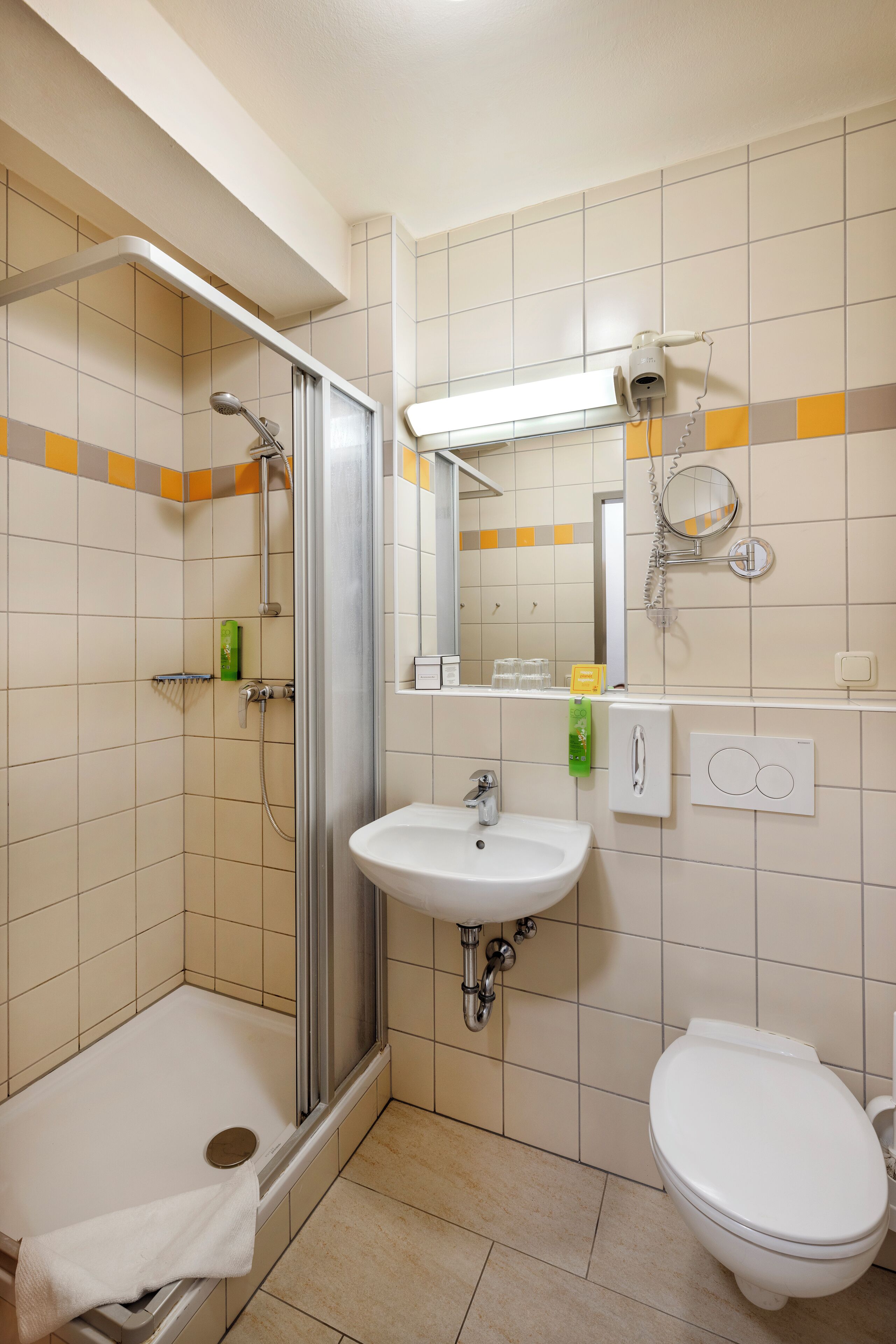 A bathroom with a shower, sink, and toilet.