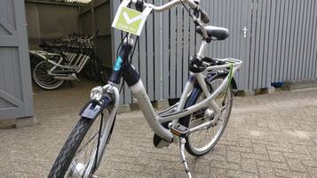 Een fiets geparkeerd voor een gebouw met een bord waarop 'Zaan Inn' staat.