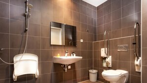 Une salle de bain moderne équipée d’une douche, d’un lavabo, de toilettes et d’un miroir.