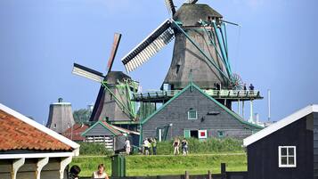 A windmill with a wooden structure in the foreground and a clear blue sky in the background.